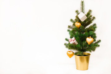 The Christmas tree is decorated with golden toys in the shape of the heart. Boxes with gifts, jewelry. A gift for her. Card. Congratulation.