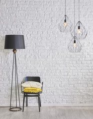 brick wall interior room concept with black lamp and metallic chair 