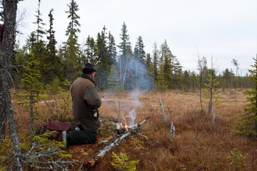 Moose hunter on knee on a morass