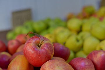 Tasty fresh red apples at grocery store.Buy & eat natural vitamin food.Farmer market department in food shop.Box of fruits on sale in fridge.Ripe red apples & oranges at food aisle in food department