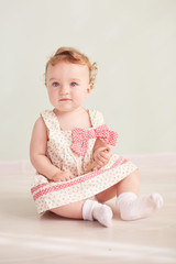 little girl is sitting in the studio and is playing