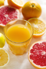 Citrus juice and fruit grapeprut, lemon and orange on a light background.