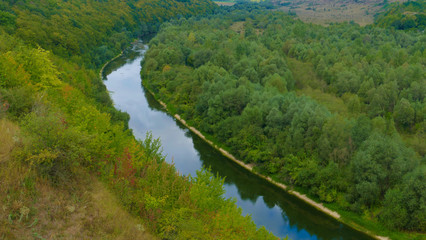 Fototapeta na wymiar A wild natural meandering river amidst meadows and forests. The photo shows the beauty of eastern nature not destroyed by human exploitation yet.