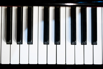 Naklejka premium piano keyboard black and white theme top view with dark vignette