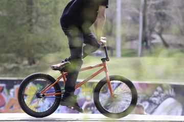 Fototapeta premium Side Profile Photo of BMX Rider in colorful grafitti skate park red bike pedaling