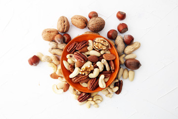 bowl with mixed nuts on white background. Healthy food and snack. Walnut, pecan, almonds, hazelnuts and cashews