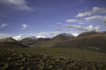 Fototapeta premium A Wide Angle Landscape shot of the beautiful mountains in the Altiplano of Bolivia, with bright clear skies and colorful desert below