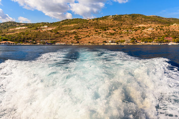 Water trail foaming behind a cruise boat. Bay of Agios Nikolaos  on Zakynhos island. Greece.