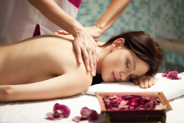 Plakat Spa salon: Beautiful Young Woman having Massage at her Back