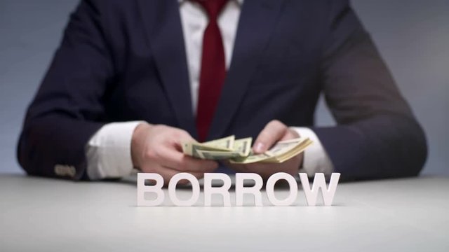 Businessman hands consider banknote from a bundle of money for borrow to partner