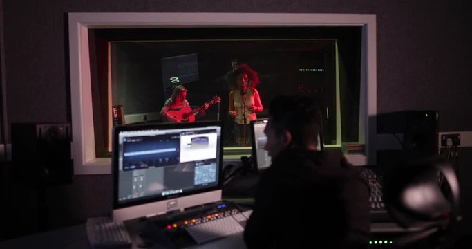 Music producer working with band in recording studio