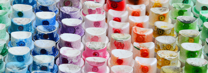 A pattern from a many nozzles from a paint sprayer for drawing graffiti, smeared into different colors. The plastic caps are arranged in many rows forming the color of the rainbow © mehaniq41
