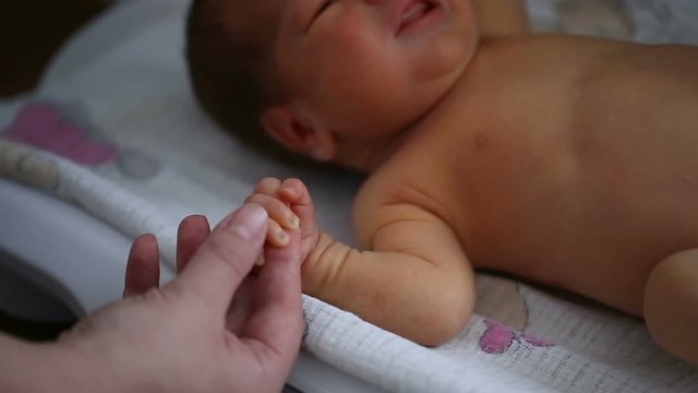 Mother measuring weight of her newborn baby
