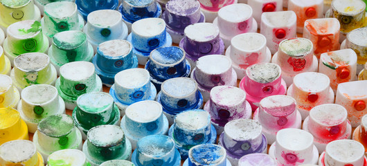 A pattern from a many nozzles from a paint sprayer for drawing graffiti, smeared into different colors. The plastic caps are arranged in many rows forming the color of the rainbow © mehaniq41