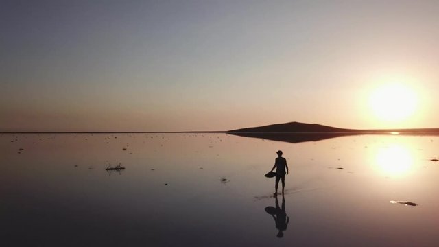 Arial Of View From Drone When People Walk And Run Around The Salt Pink Lake At Sunset In The Backlight In 4K