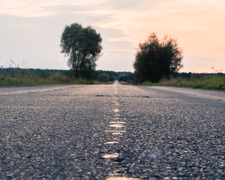 Low Angle View Of Asphalt Country Road During Sunset