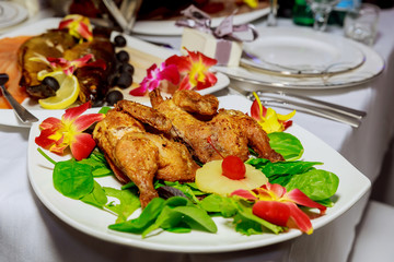 grilled half chicken served on a plate, napkin and silverware, background fades to white,