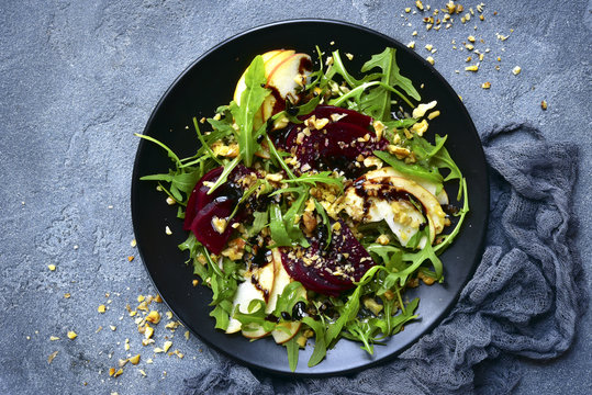 Vegetable salad with beetroot,apple,walnut and arugula leaves.Top view.