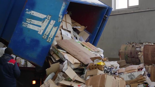 Logistics at the waste processing plant. Truck brought the waste paper to the garbage processing plant. Unloading of recyclable materials in the warehouse of the waste processing plant.