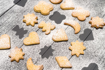Christmas different shaped cookies with sugar powder on wooden table
