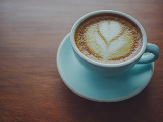 Coffee cup heart-shaped  on wooden table at bar counter Vintage color, filter effect.