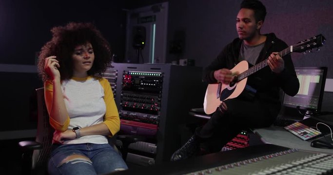 Band working on a track together in a recording studio