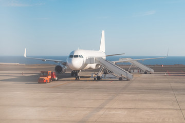 Fototapeta na wymiar airplane standing on runway with stairs ready for boarding