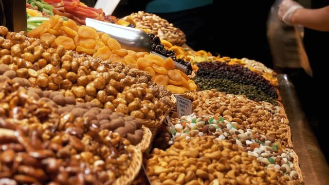 Large Counter of Dried Fruits and Nuts at a Market in La Boqueria. Barcelona. Spain. Nuts, dry fruits on display at the market on the showcase. Stall with Various dried fruits at Mercat de Sant Josep.