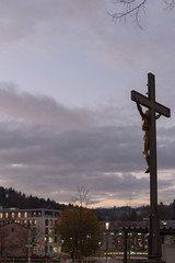sunset city lights and symbols of a historical city like old tower and crucifix