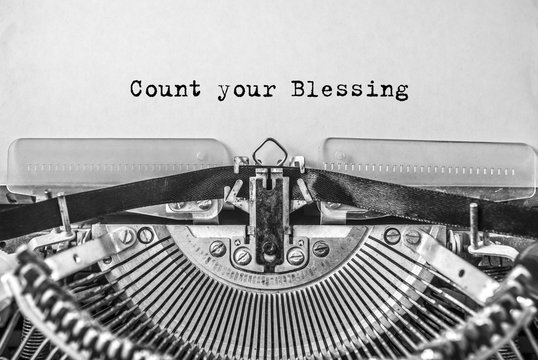 Vintage old typewriter on white background with text Count your Blessing. Close up.