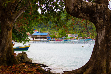 Blue beach of Sapzurro town from a view framed by trees. Colombia, Chocó