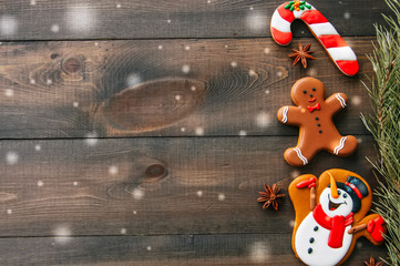 Christmas background. Different shapes of gingerbread cookies and decorations on a wooden backdrop. Copy space and top view.Toned.