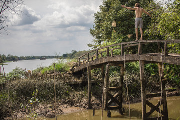 Man balancing on the edge of old bridge