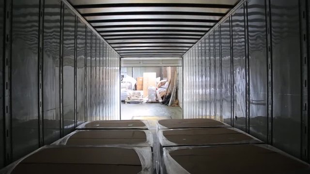 Worker on the loader unload semi-trailer. Shooting from inside of the trailer. Timelapse.