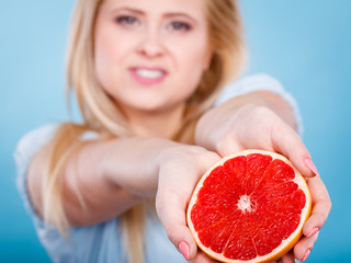Woman holds grapefruit citrus fruit in hands