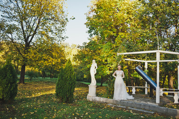 Portrait of a bride standing near the overgrown plants of the gazebo 244.
