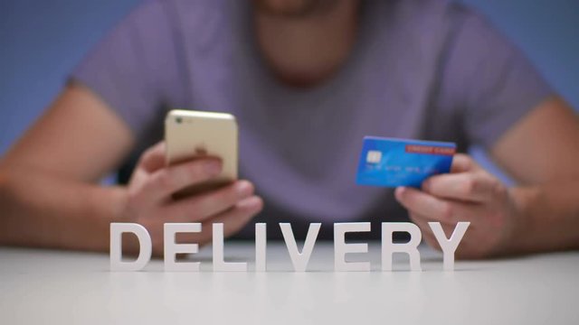 Man using mobile phone orders delivery food to house and payment by credit card