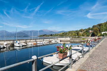 Town of Reno, lake Maggiore, northern Italy. Lakefront of the picturesque village on Lake Maggiore and its small harbor. In the background the towns of Verbania and Pallanza and the Alps 