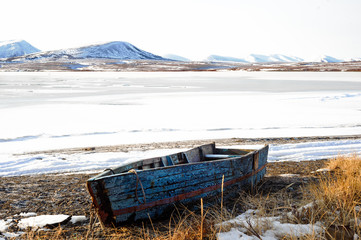 Fototapeta na wymiar Old boat on the shore on the winter background 