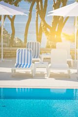sunbeds and umbrellas by the swimming pool on a sunny day