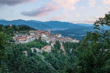 Fototapeta na wymiar Sacro Monte of Varese (Santa Maria del Monte), Varese - Italy. Picturesque view of the small medieval village at sunset. Below the funicular is visible. World heritage site - UNESCO site