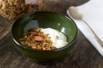 Useful breakfast is yoghurt with granola. Granola with yoghurt in a ceramic bowl and granola in a glass.