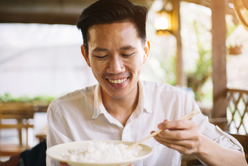 Male Asian eating rice