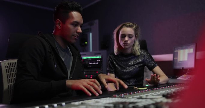 Producer and singer playing back a recorded track