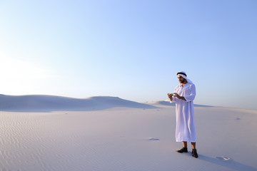 Cheerful Arab male tourist calls friend on Skype by cell and sho