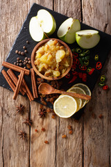 Indian apple chutney with ingredients close-up on the table. Vertical top view