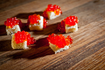 Red caviar with bread and butter on a dark background
