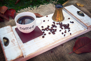 Fototapeta na wymiar cup of coffee with beans on vintage wooden tray