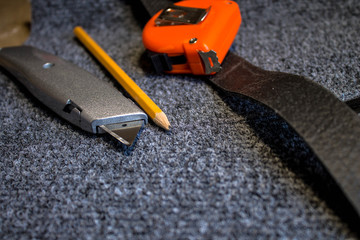 Grey roll of carpet and a knife for slicing