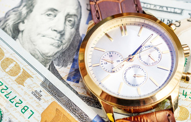 Wrist watch with dollar bills. Close up. Business concept. Financial background.